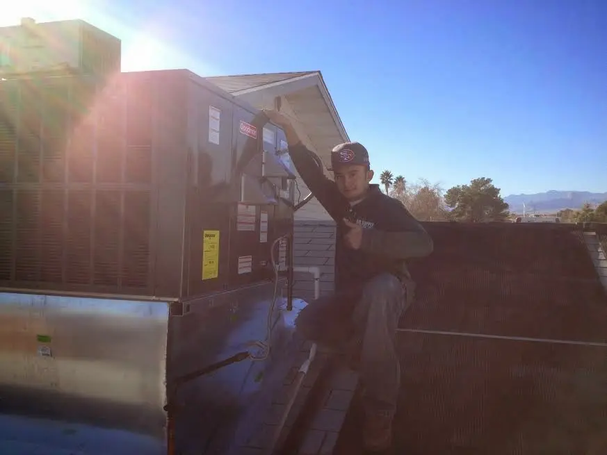 HVAC technician performing Heat Pump Repair on a rooftop unit in Vineyard